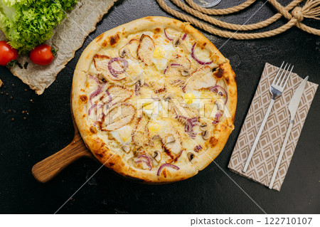 Gourmet pizza with grilled chicken, mushrooms, red onion, quail eggs, and parmesan 122710107