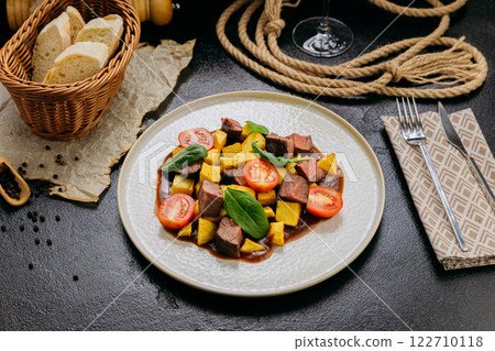 Gourmet beef cubes with roasted potatoes, cherry tomatoes and spinach with rich sauce and wine 122710118