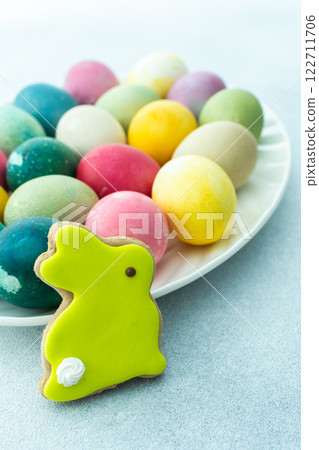 Multi-colored Easter eggs in an oval dish on a blue background, Happy Easter holiday 122711706