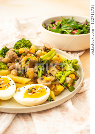 Pasta with fried mushrooms and broccoli, green peas and corn, fresh mix salad Pasta with fried mushrooms and broccoli, green peas and corn, fresh mix salad 122711722