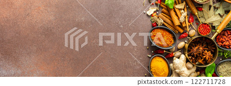 A visually striking arrangement of fresh spices and herbs on a brown surface, highlighting their vivid colors, intricate details, and rich culinary essence, banner 122711728