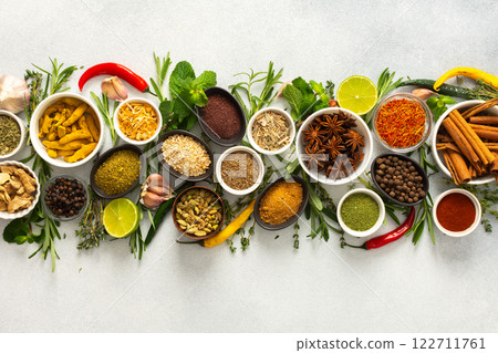 A collection of various spices and herbs on a gray background, perfect for enhancing dishes with rich flavors and textures A collection of various spices and herbs on a gray background, perfect for enhancing dishes with rich flavors and textures 122711761