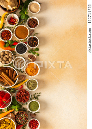 Spread of spices and herbs on a beige surface, featuring essential cooking ingredients for flavorful, home-cooked recipes, top view and copy space Spread of spices and herbs on a beige surface, featuring essential cooking ingredients for flavorful, home-cooked recipes, top view and copy space 122711763