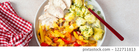 A wholesome dish featuring boiled potatoes, baked vegetables, chicken breast, and a vibrant salad with seeds 122711813