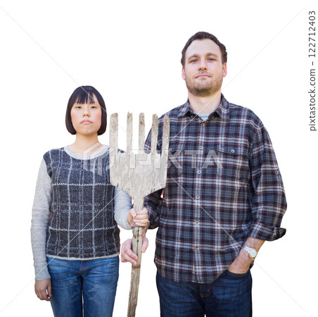 Mixed Race Chinese and Caucasian Couple Standing and Holding a Wooden Pitch Fork Isolated on a White Background. Mixed Race Chinese and Caucasian Couple Standing and Holding a Wooden Pitch Fork Isolated on a White Background. 122712403