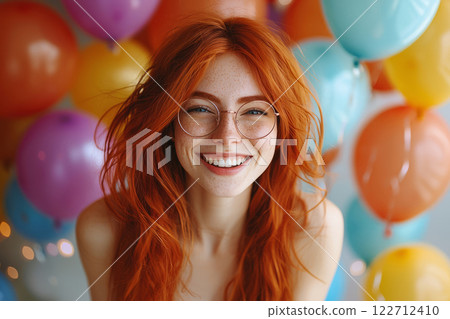 Smiling red haired woman with freckles at festive celebration 122712410