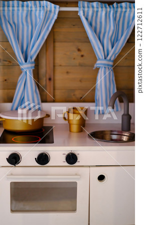 A small kitchen with a stove and a sink. 122712611