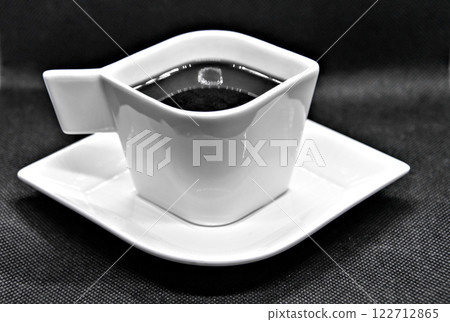 Cup of coffee on plate on black background Cup of coffee on plate on black background 122712865