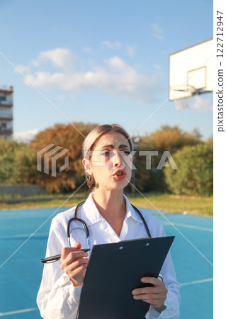 Doctor Carefully Writing on Notepad in Field Clinic Doctor Carefully Writing on Notepad in Field Clinic 122712947