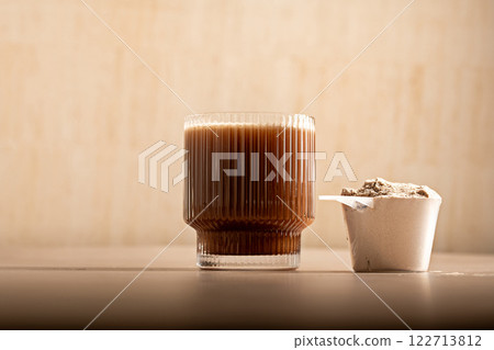 Chocolate protein powder in a measuring scoop. Nutrition and food supplement 122713812