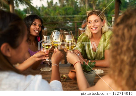Diverse women toasting in outdoor restaurant. Friends gather, celebrate, share laughter. Perfect for women empowerment, friendship, International Women Day, social bonds. Diverse women toasting in outdoor restaurant. Friends gather, celebrate, share laughter. Perfect for women empowerment, friendship, International Women Day, social bonds. 122714015