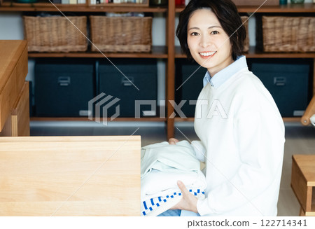 Woman folding clothes 122714341