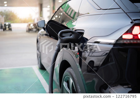 Charging electric cars at charging stations Using electric cars that save energy and reduce air pollution Charging electric cars at charging stations Using electric cars that save energy and reduce air pollution 122716795