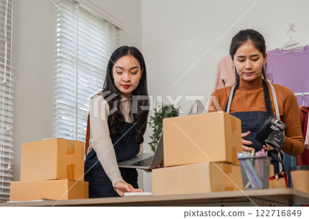 Diverse couple managing online orders and packaging in their boutique workspace. Diverse couple managing online orders and packaging in their boutique workspace. 122716849