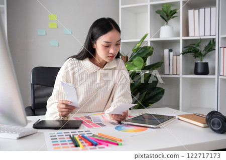 Female designer working in graphic design Choose colors for working on tablets and computer designs. Female designer working in graphic design Choose colors for working on tablets and computer designs. 122717173