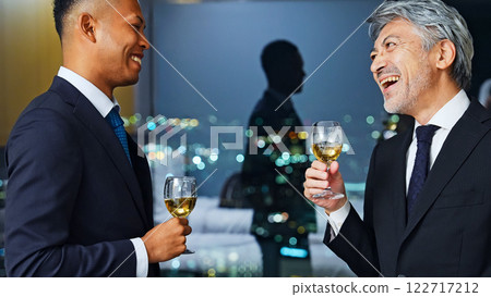 Multinational business people toasting with the city night view in the background Multinational business people toasting with the city night view in the background 122717212