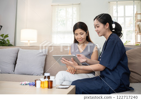 A young woman who takes care of the sick sits and gives advice to a retired woman about health care and the use of tonics. A young woman who takes care of the sick sits and gives advice to a retired woman about health care and the use of tonics. 122717240