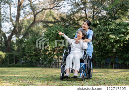 Nurse and Elderly Patient Enjoying a Peaceful Moment in the Garden Together Nurse and Elderly Patient Enjoying a Peaceful Moment in the Garden Together 122717305