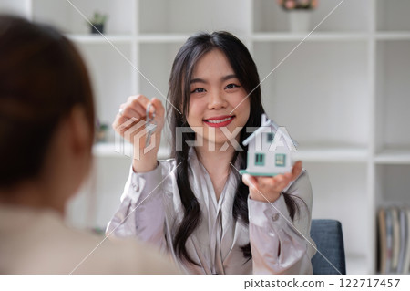 Home sales and real estate agent provide home models to clients to complete sale contract with. Home sales and real estate agent provide home models to clients to complete sale contract with. 122717457