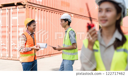 Construction team engaging in discussion with blueprints and communication tools on-site Construction team engaging in discussion with blueprints and communication tools on-site 122717462