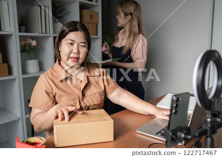 E-commerce entrepreneur discussing packaging strategies with assistant while preparing for live stream in home office E-commerce entrepreneur discussing packaging strategies with assistant while preparing for live stream in home office 122717467