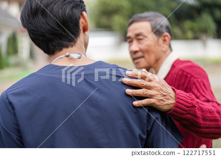 Elderly man showing gratitude to healthcare worker with a supportive touch outdoors Elderly man showing gratitude to healthcare worker with a supportive touch outdoors 122717551
