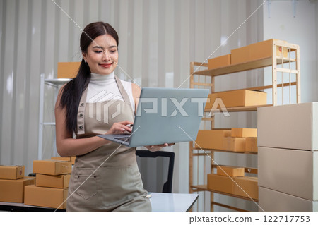 A small SME business owner uses a laptop to record small business information in his home office. A small SME business owner uses a laptop to record small business information in his home office. 122717753
