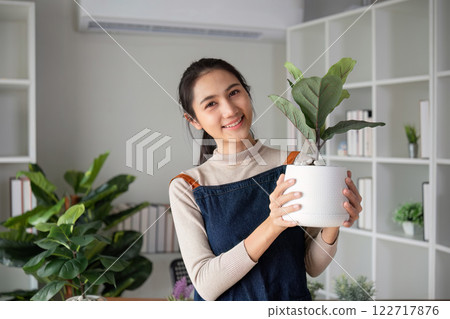 A young Asian woman is enjoying planting a garden in her home to create a shady atmosphere in her home. A young Asian woman is enjoying planting a garden in her home to create a shady atmosphere in her home. 122717876