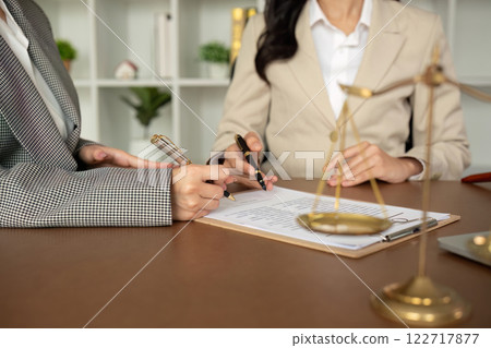 A lawyer and a businesswoman are discussing legal advice on signing a business contract. Signing an insurance or financial contract 122717877
