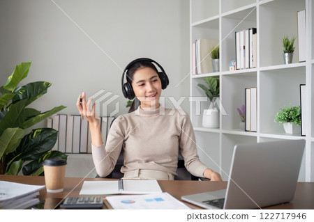 Young Asian student studies online about graphs and statistics. Happy Zoom video call studying with laptop computer 122717946