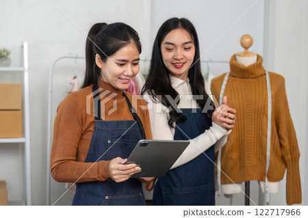 Women fashion designers reviewing designs on a tablet, collaborating in a boutique on tailored clothing 122717966