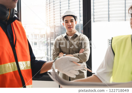Handsome young chief engineer standing during engineer team discussion at construction site 122718049