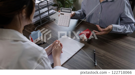 Village project representative and customer discuss purchase contract and home insurance. or real estate loans Village project representative and customer discuss purchase contract and home insurance. or real estate loans 122718066