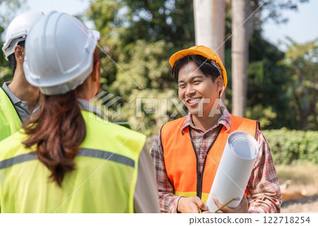 Logistics engineering team celebrating project milestones and discussing blueprints on a sunny construction site Logistics engineering team celebrating project milestones and discussing blueprints on a sunny construction site 122718254