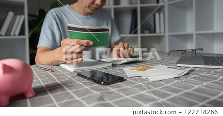 Elderly man analyzing savings with a calculator and wallet at his home office Elderly man analyzing savings with a calculator and wallet at his home office 122718266