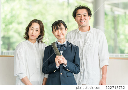 Middle school girl and parents holding a diploma 122718732
