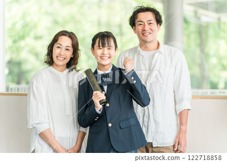 Middle school girl and parents holding a diploma 122718858