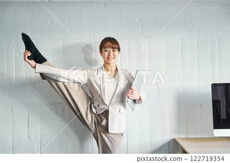 A woman who raises one foot 122719354