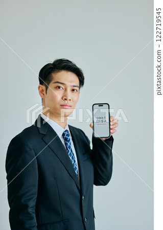 一名二十多歲的年輕人拿著智慧型手機 一名二十多歲的年輕人拿著智慧型手機 122719545