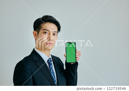 一名二十多歲的年輕人拿著智慧型手機 一名二十多歲的年輕人拿著智慧型手機 122719546