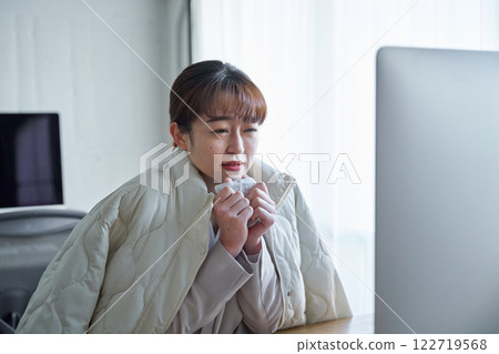 一名婦女在寒冷的辦公室裡凍僵了 一名婦女在寒冷的辦公室裡凍僵了 122719568