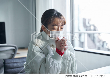 一名婦女在寒冷的辦公室裡凍僵了 122719569