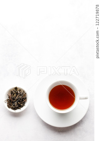 Cup of hot tea with tea leaf on white table background. 122719878
