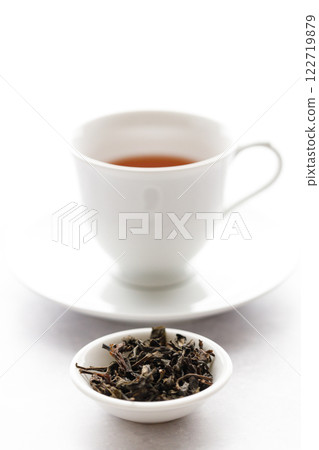 Cup of hot tea with tea leaf on white table background. Cup of hot tea with tea leaf on white table background. 122719879