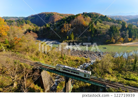 Late autumn in Sakae Village, Shinshu. A local train on the JR Iiyama Line crossing an iron bridge seen from Sakae Ohashi Bridge along the Chikuma River. Late autumn in Sakae Village, Shinshu. A local train on the JR Iiyama Line crossing an iron bridge seen from Sakae Ohashi Bridge along the Chikuma River. 122719939