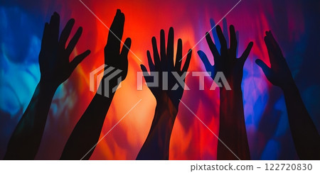 Silhouetted Hands Reaching Up Against Vibrant Red and Blue Background 122720830