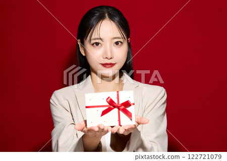 Fashionable young woman holding gift box 122721079