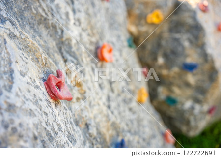 Close up view of a short rock climbing wall on the playground, concept of developing strength and coordination of children Close up view of a short rock climbing wall on the playground, concept of developing strength and coordination of children 122722691