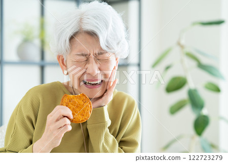 Senior woman eating rice crackers 122723279