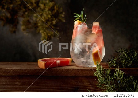 Cocktail: gin and tonic with ice, grapefruit, and rosemary. Cocktail: gin and tonic with ice, grapefruit, and rosemary. 122723575